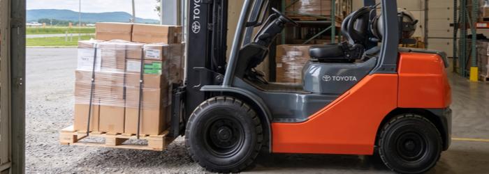 Chariot élévateur au propane transportant une palette de marchandises.